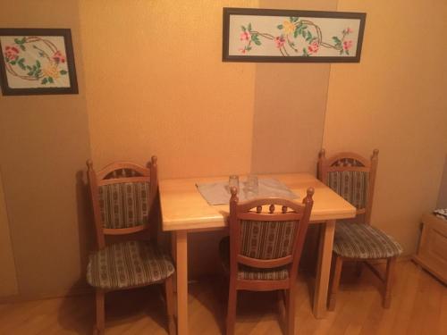 uma mesa de jantar com 4 cadeiras e uma mesa de madeira em Hotel Svitlytsia em Tyachiv