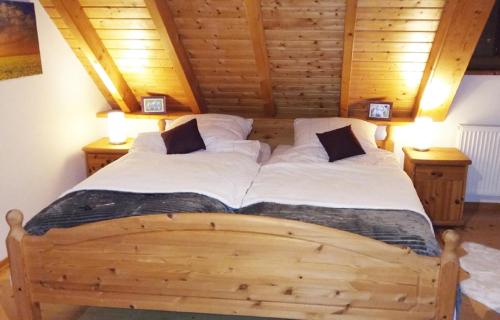 een groot houten bed in een kamer met houten plafonds bij Ferienwohnung Auf Schäfers Spuren in Buergstadt