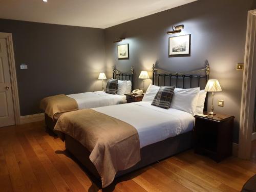 a hotel room with two beds and two lamps at The Listowel Arms Hotel in Listowel