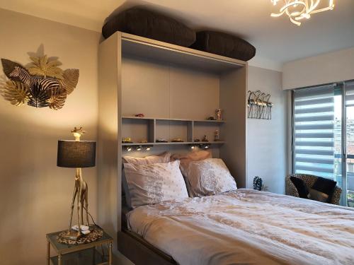 une chambre avec un grand lit avec une grande tête de lit dans l'établissement Méditerranée 2, by Welcome to Cannes, à Cannes