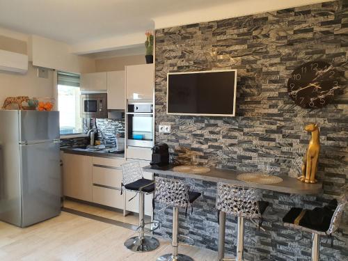 - une cuisine avec un mur en pierre, une table et des chaises dans l'établissement Méditerranée 2, by Welcome to Cannes, à Cannes