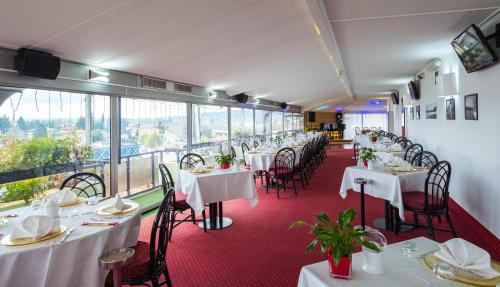 فندق أتلانتك في أرونا: مطعم بطاولات بيضاء وكراسي ونوافذ