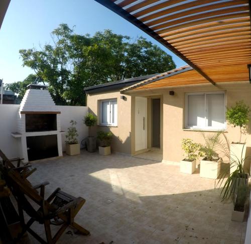 un patio de una casa con techo de madera en C1 Suite, en Las Varillas