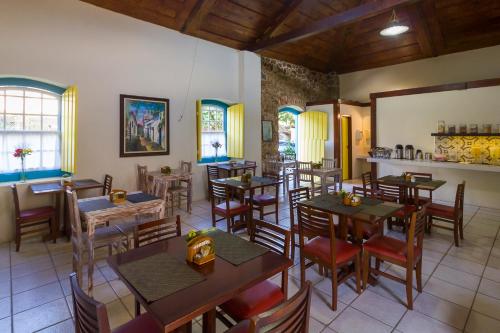 een restaurant met tafels en stoelen in een kamer bij Pousada Vila do Porto in Paraty