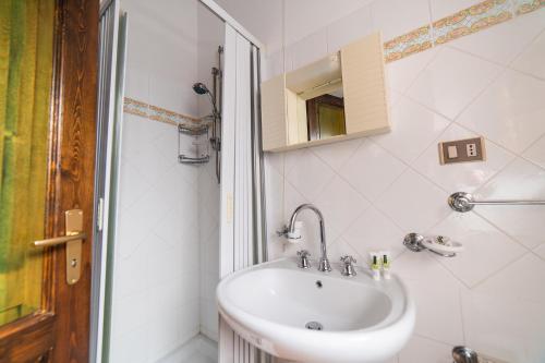 a white bathroom with a sink and a shower at Pie' d'Ulivo in Bosco