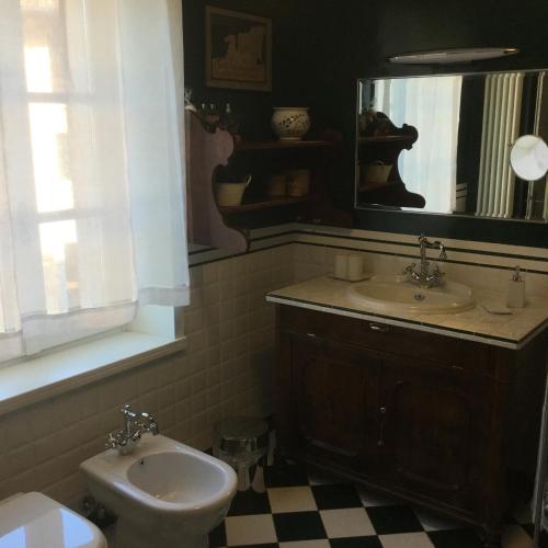 a bathroom with a sink and a toilet and a mirror at Casa Ariis in Clauiano