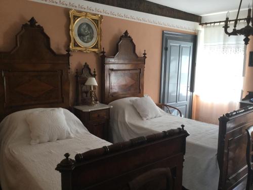 a bedroom with two beds and a clock on the wall at Casa Ariis in Clauiano