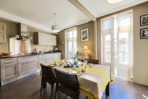 une cuisine avec une table et un chiffon de table jaune et blanc dans l'établissement Vue Magenta AP4188 by Riviera Holiday Homes, à Nice