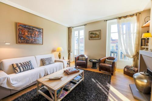 un salon avec un canapé blanc et une table dans l'établissement Vue Magenta AP4188 by Riviera Holiday Homes, à Nice