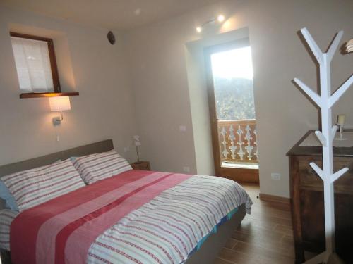 ein Schlafzimmer mit einem Bett und einem großen Fenster in der Unterkunft LA PICCIONAIA in Varallo