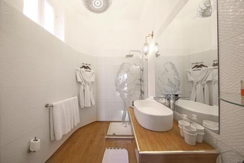 a white bathroom with a sink and a tub at Riad Anyssates in Marrakech
