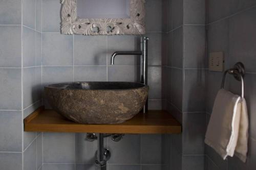 baño con un gran fregadero de piedra en una estantería de madera en Agriturismo Casariccio - Casa Viola, en Bucine