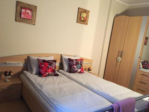 a bed with two pillows on it in a bedroom at Kara Apartman in Odorheiu Secuiesc