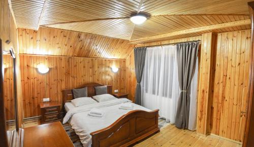 a bedroom with a large bed in a wooden room at Woodland House in Yaremche