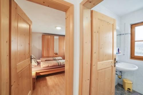 łazienka z łóżkiem i umywalką w pokoju w obiekcie Strickerhof Appartment 1 w mieście Saltusio
