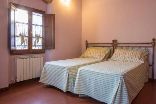 1 dormitorio con 2 camas y ventana en Agriturismo Casariccio - Casa Dalia, en Bucine