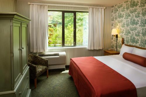 une chambre d'hôtel avec un lit et une fenêtre dans l'établissement Williamsburg Woodlands Hotel & Suites, an official Colonial Williamsburg Hotel, à Williamsburg