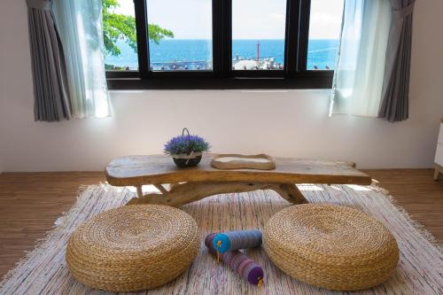 a coffee table and two stools in a room with the ocean at Na Jie 17 in Donghe