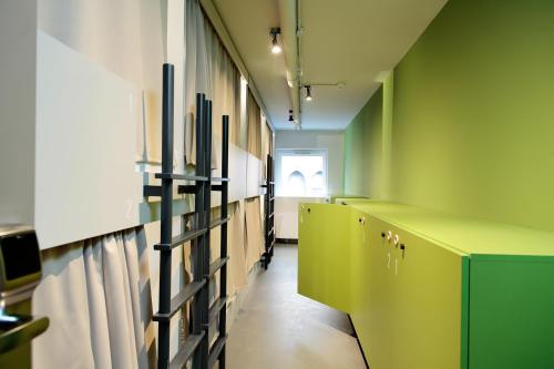 a hallway with green walls and a row of lockers at Maverick Urban Lodge in Budapest