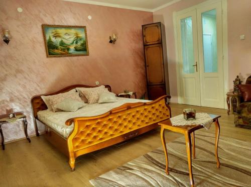 een slaapkamer met een houten bed en een tafel bij Mosaique Casa in Belgrado