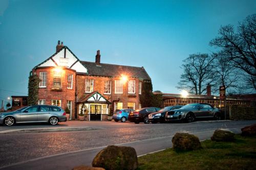 a large brick building with cars parked in front of it at The Lodge in Hunstanton