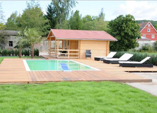 a backyard with a swimming pool and a cabin at Caseti 5 Ferienwohnungen - Rothenburg u Bad Windsheim in Oberdachstetten