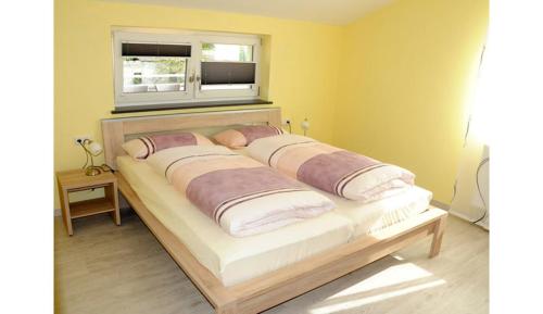 una cama en una habitación con ventana en Caseti 5_ Ferienwohnungen _ Rothen, en Oberdachstetten