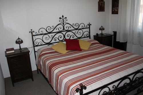 ein Schlafzimmer mit einem Bett mit einer roten und weißen gestreiften Decke in der Unterkunft La Ca' Nova in Lurago D'Erba 