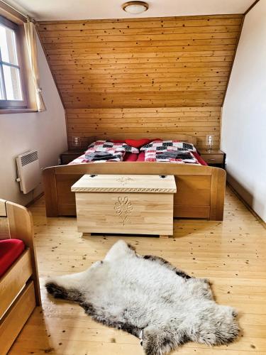 a bedroom with a bed and a rug on the floor at Drevenička Anička - Liptovská Mara in Liptovský Trnovec