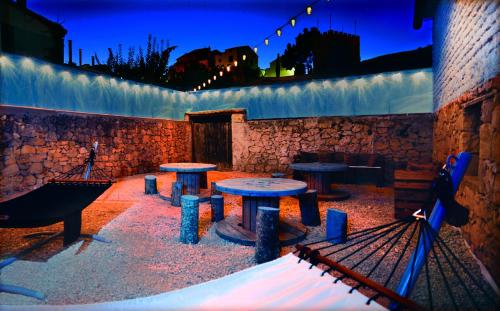 a patio with tables and benches at night at La Boutique in Nuévalos
