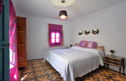 a bedroom with a white bed and a window at La Boutique in Nuévalos
