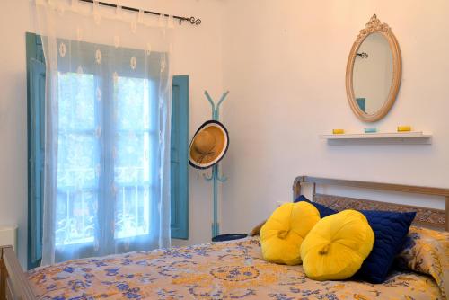 a bedroom with a bed with yellow pillows and a mirror at La Boutique in Nuévalos