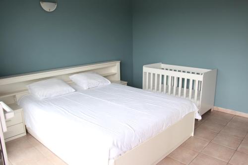 ein weißes Bett in einem Zimmer mit blauen Wänden in der Unterkunft Marina Mercator in Ostende
