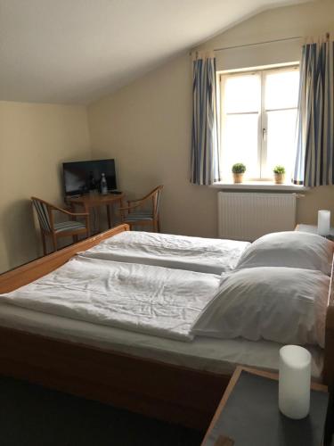 a large bed in a bedroom with a window at Landgasthaus Streichmühle in Dollerup