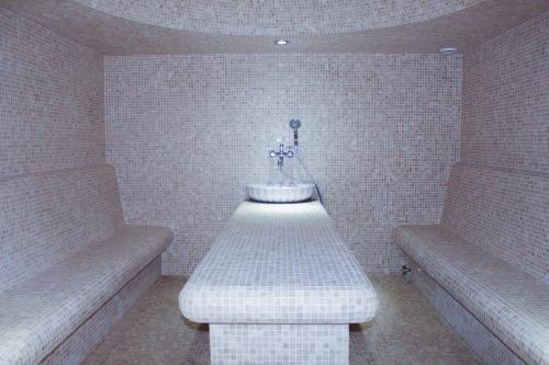 a room with two benches and a table with flowers at Familion ApartHotel in Chişinău