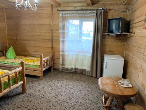 a room with two beds and a tv and a table at КРЕМІНЬ in Dragobrat