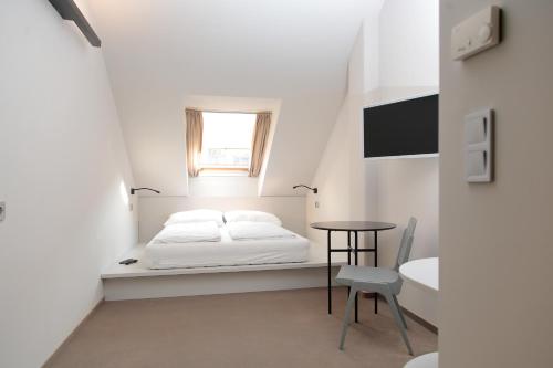 a bedroom with a bed and a table and a window at Maverick Central Market in Budapest