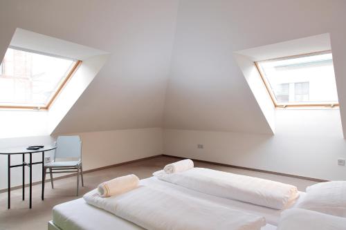 two beds in a white room with two windows at Maverick Central Market in Budapest