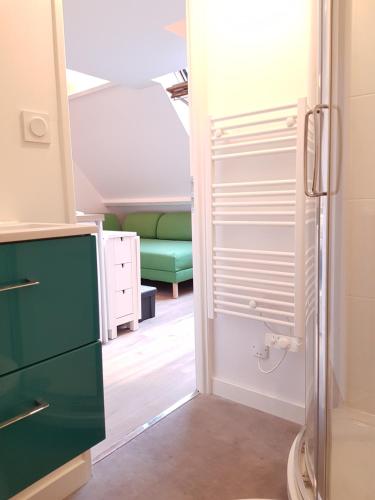 Cette petite chambre comprend un canapé vert. dans l'établissement Le Fleury - Studio calme proche de Rouen, à Déville-lès-Rouen