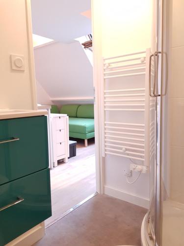 a small room with a green couch in a room at Le Fleury - Studio calme proche de Rouen in Déville-lès-Rouen