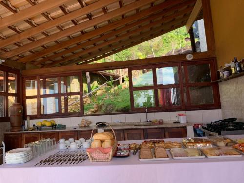 三一市的住宿－Espaço Indio Tupi，厨房配有一张桌子,里面摆放着面包和糕点
