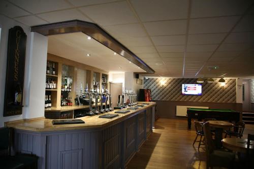 a bar in a restaurant with a tv in the background at The Fazeley Inn in Fazeley