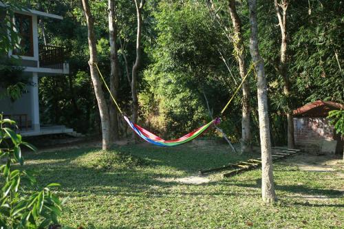 a hammock hanging between two trees in a yard at Balishira Resort Ltd. in Sreemangal