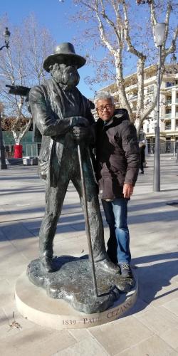 a man is standing next to a statue of a boy at Le Rhododendron Chambres D'hotes in Kathmandu