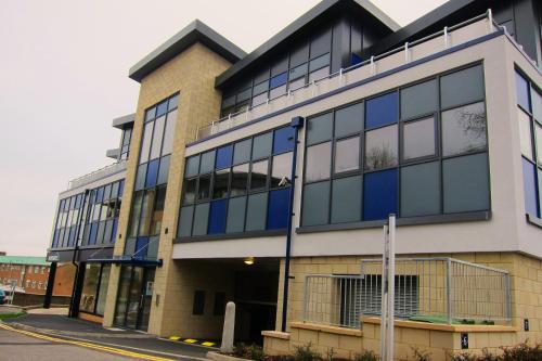 
a large building with a large window in front of it at Room Space Service Apartments – New Manor House in Bracknell
