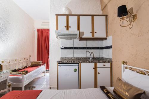 a small kitchen with a sink and a bed in a room at Oasis Studios in Malia