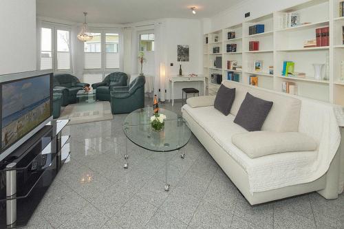 ein Wohnzimmer mit einem weißen Sofa und einem Fernseher in der Unterkunft Dünenresidenz A05 in Bansin