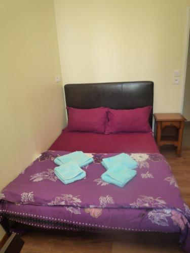 a bed with purple sheets and blue towels on it at Hôtel Lyonnais in Nice