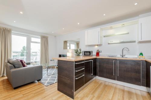 una cocina con fregadero y un sofá en una habitación en Roomspace Serviced Apartments - Abbot's Yard en Guildford