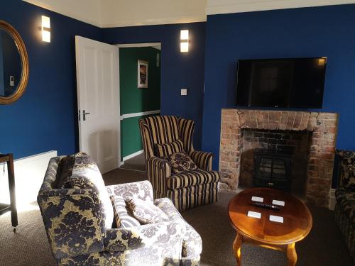 a living room with a couch and chairs and a fireplace at 2 Bedroom Apartment at Kent Escapes Short Lets & Serviced Accommodation Kent, Bouverie Escape Folkestone with Wifi in Folkestone